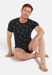 Svart t-shirt med kort ärm och blå mönster av olika figurer, ihop med matchande svarta shorts. Mjukt tyg och avslappnad passform.