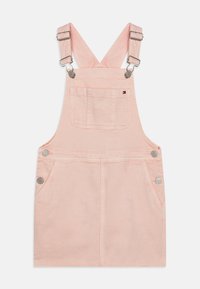 Vestido de mezclilla rosa tipo peto con tirantes ajustables, dos bolsillos frontales y acentos de botones plateados. Textura suave y diseño sencillo.