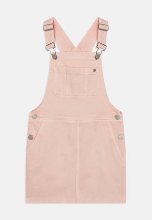 Roze denim tuinbroek jurk met verstelbare schouderbanden, twee voorkruistassen en zilveren knoopaccenten. Glad textuur en eenvoudig ontwerp.