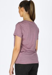 T-shirt a maniche corte, collo rotondo, realizzato in morbido tessuto mauve melangiato, con una vestibilità rilassata e una texture liscia. La vista posteriore mostra dettagli di design minimi.
