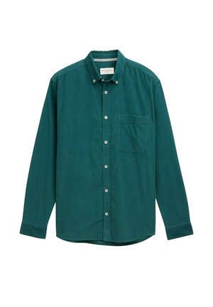 Zilais krekls ar garām piedurknēm, vienu krūšu kabatu un noapaļu apakšmalu. Izgatavots no viegla auduma ar gludu tekstūru.