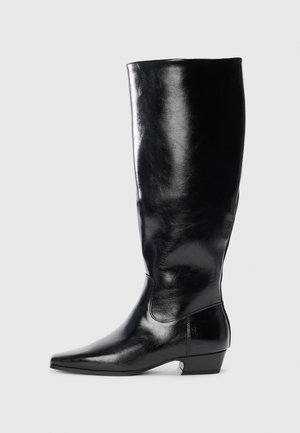 Bota de cuero negro hasta la rodilla con un acabado brillante, punta afilada y tacón bajo. Presenta una textura suave y un diseño minimalista.