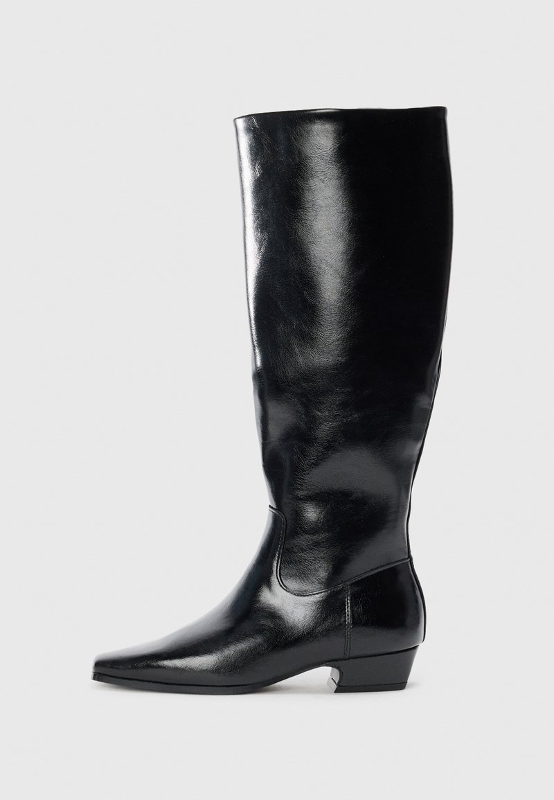 Μαύρη δερμάτινη μπότες μέχρι το γόνατο με γυαλιστερή φινέτσα, μυτερή μύτη και χαμηλό μποτάκι. Διαθέτει απαλό υλικό και μίνιμαλ σχεδίαση.