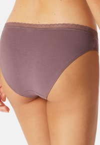 Slip in cotone viola con bordo in pizzo in vita. Texture liscia, forma aderente e costruzione senza cuciture per un comfort ottimale.