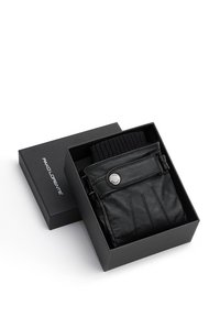 Czarne skórzane rękawice z prążkowanym czarnym ściągaczem, zapięte srebrnym guzikiem, zaprezentowane w czarnym pudełku z logo marki.