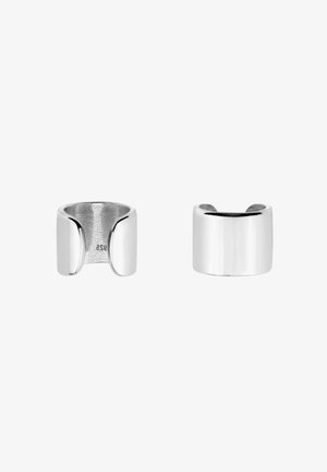 Zilveren metalen ring met een gladde, gepolijste afwerking. Heeft een brede bandvorm en subtiele openingen aan de zijkanten voor een modern ontwerp.