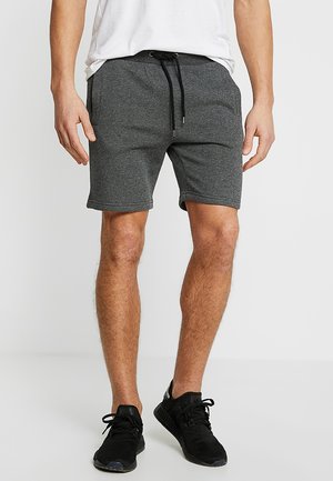 Gray athletic shorts featuring a drawstring waist, side pockets, and a comfortable fabric blend. Worn with black athletic shoes.