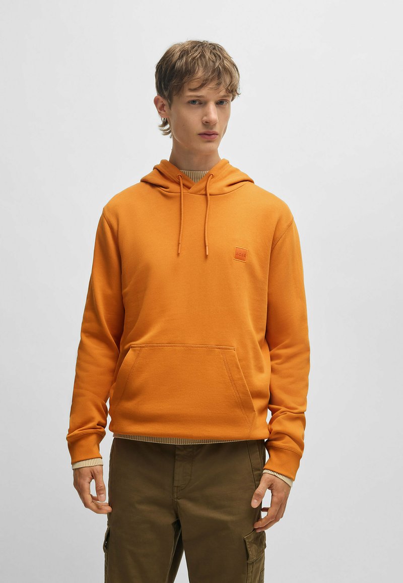 Oranje capuchon sweatshirt met een voorzak, ribgebreide zoom en logo label. Voorzien van lange mouwen en een zachte, gestructureerde stof.