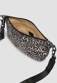 Leopardprint schoudertas met een ritssluiting, zwarte band en een beige binnenvoering, met een binnenzak voor organisatie.
