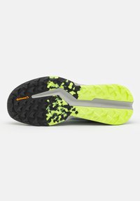 Suela de zapato que presenta una parte superior negra con un vibrante patrón de tracción de goma amarillo neón, acentos grises y la marca Continental.
