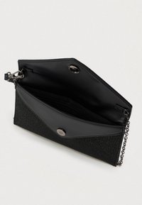 Čierna kabelka s textúrovaným sieťovým povrchom, hladkým koženým uzáverom a vnútrom, obsahujúca reťazový popruh a západkové uzatvorenie.