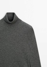 Pull à col roulé gris en tissu tricoté doux. Il présente un col haut et des manches longues, avec une texture lisse et un design minimaliste.