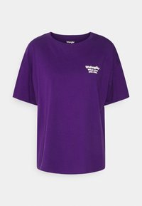 Lila kortärmad t-shirt i bomull. Har rundad halsringning och har vit text som säger "Wrangler What ever you ride."