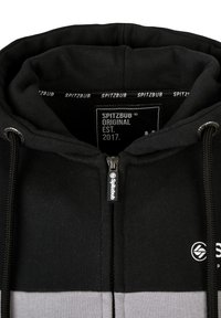 Zwart en grijs zip-up hoodie met een trekkoordcapuchon, voorzien van een textiellabel en een logo aan de voorkant. Soepele stoftextuur, gemiddelde gewicht.
