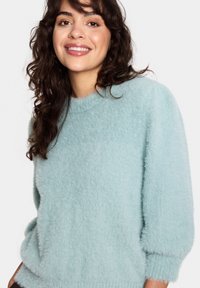 Light blue fluffy sweater with a round neckline and elbow-length sleeves, featuring a soft texture and relaxed fit.
