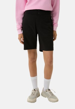 Zwarte shorts met een gestroomlijnd ontwerp, voorzien van een zachte textuur, twee knopen in de taille en zijzakken. G gedragen met een roze trui.