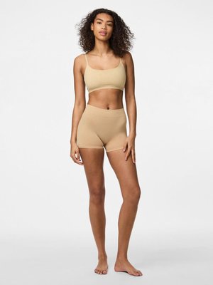 Beige elastic crop top and matching shorts, seamless design, smooth texture, fitted style, minimalistic with thin straps and short legs.