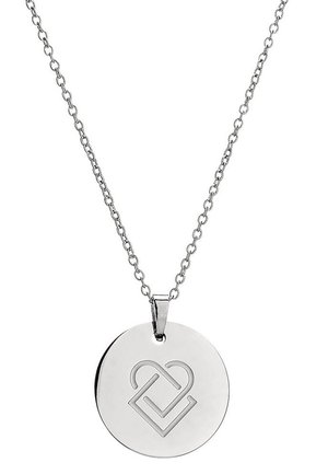 Collier pendentif circulaire en argent avec un design gravé en forme de cœur en pièces de puzzle sur une chaîne fine.