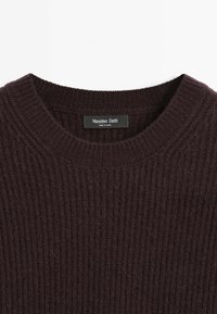 Bruine geribde trui met een ronde hals en een label met de tekst "Massimo Dutti." De stof lijkt zacht met een gestructureerd oppervlak.
