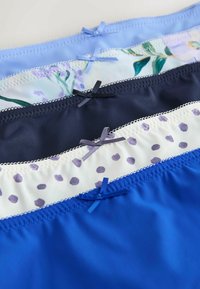 Cinq sous-vêtements en coton pour femmes en bleu, blanc à pois violets, marine, motif floral et bleu clair, chacun avec un petit nœud décoratif.