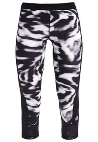 Zwart-witte gepatterneerde capri leggings met een aansluitend ontwerp, elastische tailleband en een accentlogo op de onderste linkerpijp.