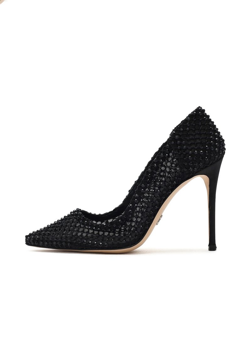 Escarpin noir à talon haut avec un embout pointu, arborant un dessus texturé orné de sequins noirs et un talon aiguille mince.