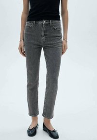 Szare dżinsy denimowe z prostą nogawką, pięcioma kieszeniami i widocznym przeszyciem. W połączeniu z czarnymi balerinami i dopasowaną czarną bluzką.