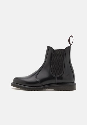 Botte Chelsea en cuir noir brillant avec panneau latéral élastique, semelle rainurée et languette à l'arrière, sur fond blanc uni, vue de l'extérieur.