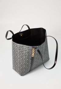 Borsa tote in tela nera e grigia con motivo del logo DKNY, manici in pelle liscia, design a apertura superiore e chiusura a pulsante all'interno.