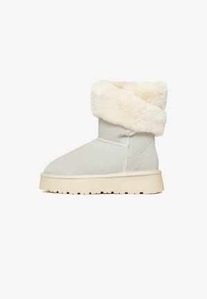 Graue Wildleder-Booties mit einem weichen, flauschigen cremefarbenen Kunstfellbund und einer dicken, beigen Sohle mit strukturiertem Profil.
