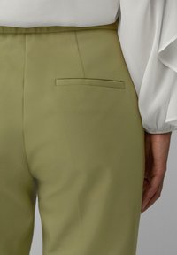 Olijfgroene broek van textuurmateriaal, met een enkele achterzak en een nette, op maat gemaakte pasvorm met een soepele tailleband.