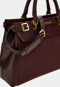 Donker bordeaux handtas van gestructureerd fauxleer, met gouden hardware, dubbele handvatten en een afneembare schouderband. Heeft een krokodillen-embossed ontwerp.