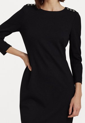 Vestito nero con scollatura a barca e maniche a tre quarti. Presenta bottoni decorativi argento sulle spalle, tessuto liscio e forma aderente.