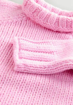 Pink knitted sweater with a ribbed collar. Material is soft, chunky yarn featuring vertical and horizontal knit patterns.