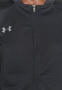 Black zip-up sweatshirt with smooth, athletic fabric, featuring a silver logo on the left chest and a close-fitting collar design.