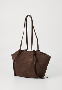 Braune Wildleder-Tasche mit zwei langen Griffen, in runder Form und mit gesteppten Details an den Seiten. Weiche Textur, keine sichtbaren Beschläge.