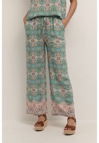 Lightweight, patterned pant set with a drawstring waist; features a turquoise base, floral accents, and wide legs, matched with tan espadrille wedges.
