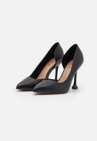 Escarpins noirs à talon haut avec un bout pointu, tige en cuir lisse et un design de talon géométrique distinctif. Présente une forme à dos ouvert.