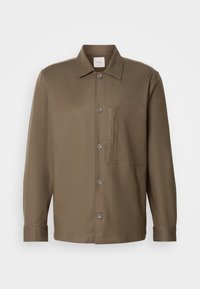 Camisa marrón de botón en tejido suave que presenta un cuello, un bolsillo frontal y seis botones, con mangas largas y un dobladillo recto.