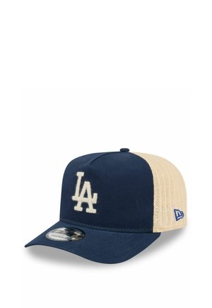 Donkerblauwe en beige baseballpet met wit "LA"-logo aan de voorkant en blauw merkembleem op het beige gaasachterpaneel.