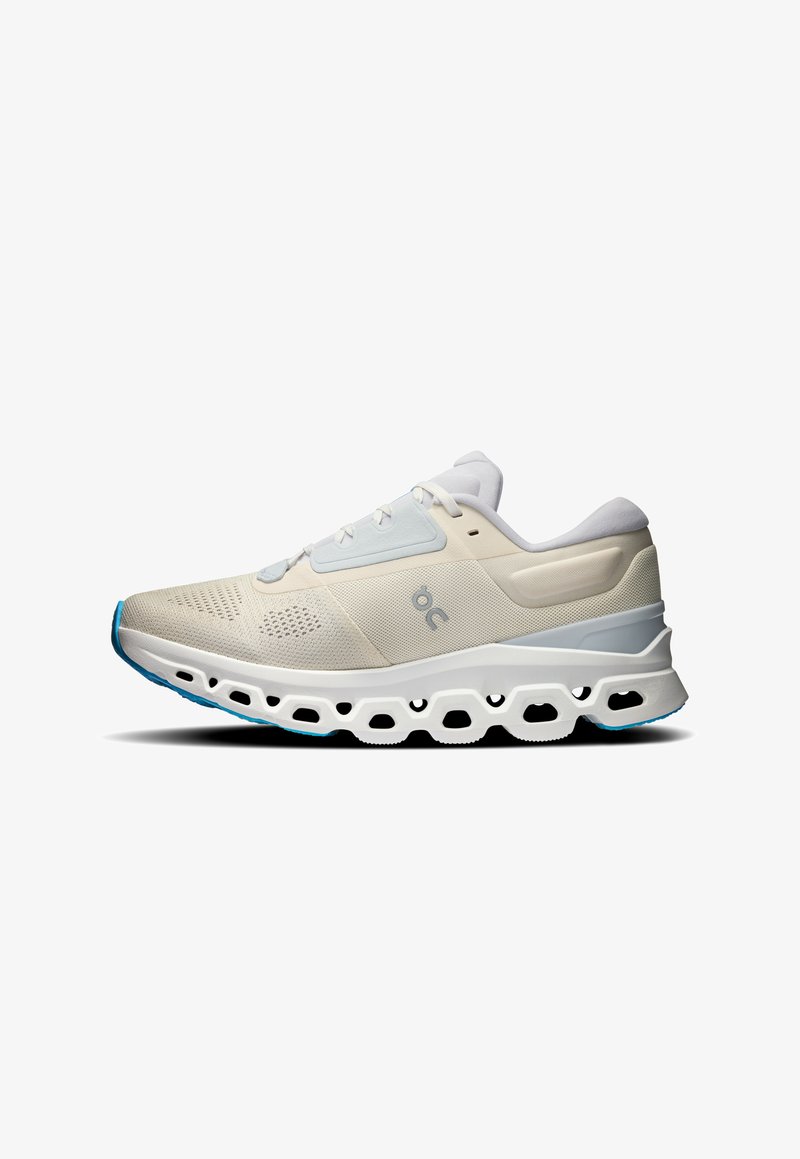 Laufschuhe in Hellbeige und Weiß, mit einem Obermaterial aus Mesh, gedämpfter Sohle und einem markanten Ausschnittmuster auf der Laufsohle.