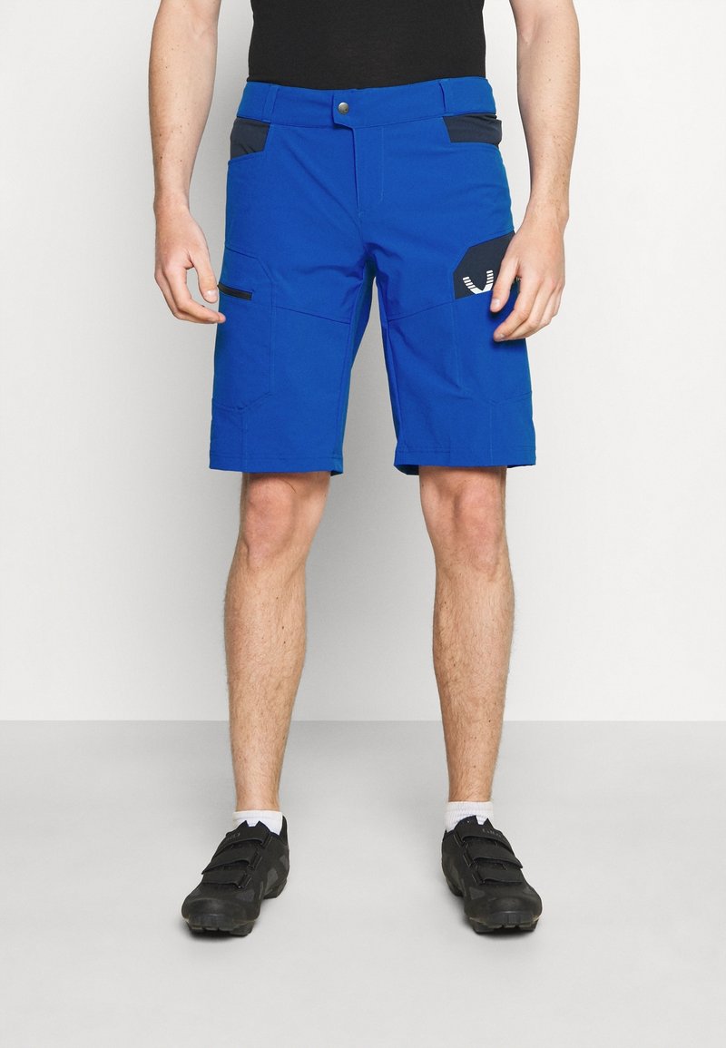 Siniset cargo-shortsit mustilla yksityiskohdilla, useita taskuja ja vetoketjukiinnitys. Kangas näyttää tukevilta ja siinä on sileä pinta.