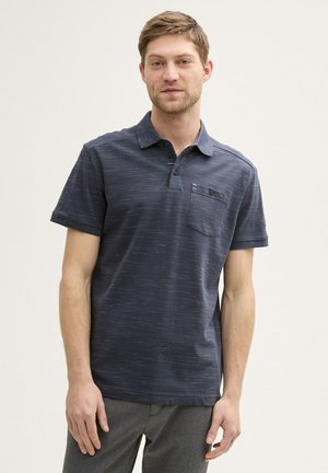 Navyblaues Polohemd mit subtilen texturalen Mustern, Knopfleiste mit drei Knöpfen und einer Brusttasche. Kurze Ärmel und eine lockere Passform.