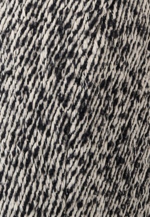 Tessuto con un motivo texturizzato in nero e crema. Il materiale appare tessuto con fibre visibili che creano un design a righe.