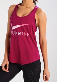 Canotta sportiva color bordeaux con la scritta "RUNNING" stampata in bianco, dotata di scollatura a barchetta e design racerback, abbinata a leggings neri.