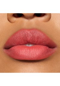 Couleur à lèvres mate dans une teinte rose tendre, texture douce, avec des lèvres supérieures et inférieures légèrement plus pleines, aspect naturel avec un éclat subtil.