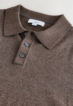Brun polo skjorte med en tekstureret stof, der har en foldet krave og tre mørke knapper ved placket. Etiket inkluderer "NEXT."