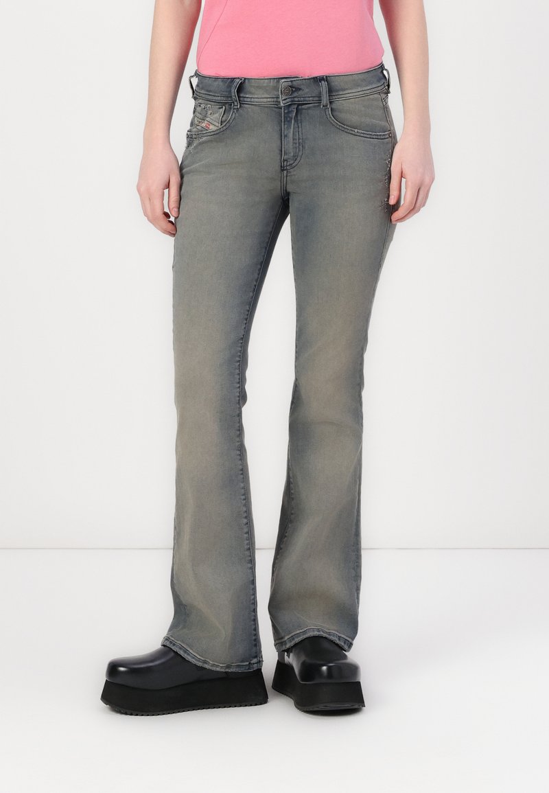 Grå vide jeans med en falmet vask, forlommer og subtile syninger, kombinert med kraftige svarte platåsko.