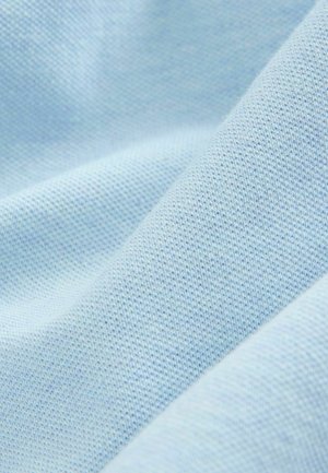 Hele sinine kangas, millel on pehme, tekstuuriga pind, millel on peen, ühtlane koepattern, luues siledat ja paindlikku välimust.