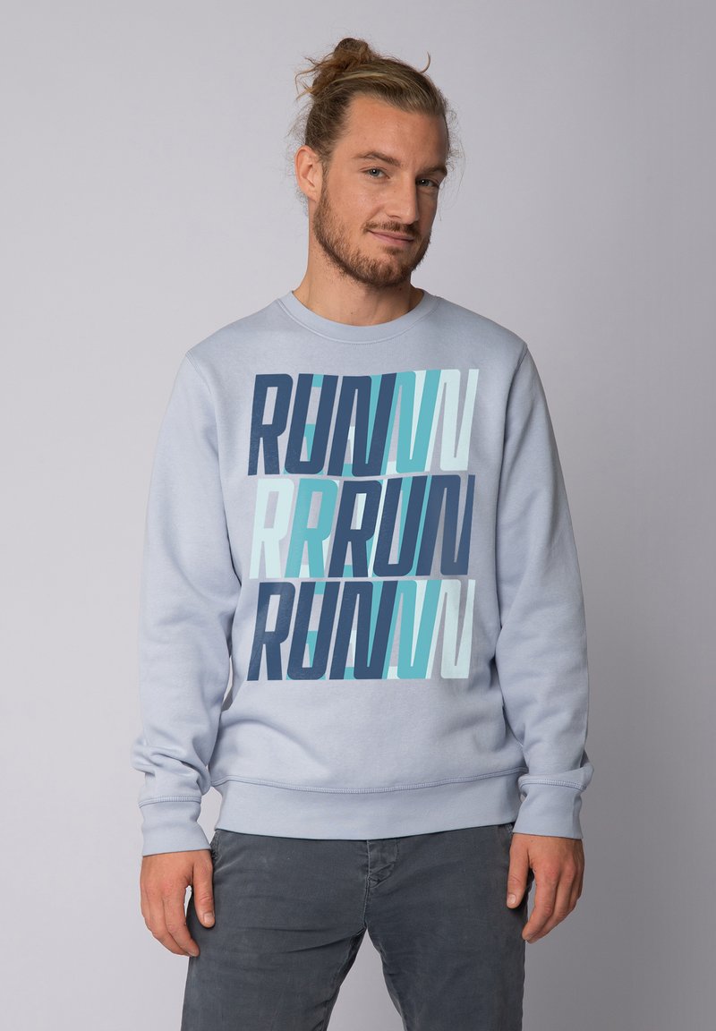 Hellblaues Sweatshirt mit einem auffälligen, geschichteten "RUN"-Grafikdesign in verschiedenen Blautönen. Es hat lange Ärmel und gerippte Bündchen.